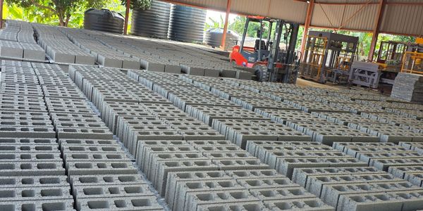 Rows of concrete blocks neatly arranged in a covered storage area.