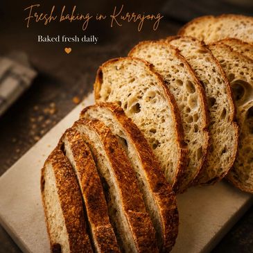 Freshly baked sliced bread with a golden crust on a cutting board.