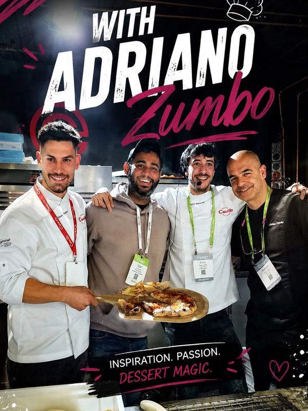 Four men, including chef Adriano Zumbo, proudly display a freshly baked pizza.