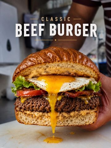 Close-up of a classic beef burger with a dripping fried egg yolk.