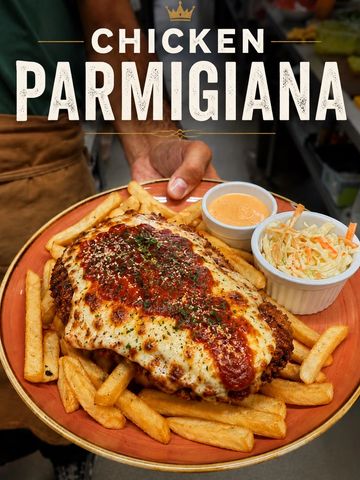 A plate of chicken parmigiana with fries, coleslaw, and dipping sauce.