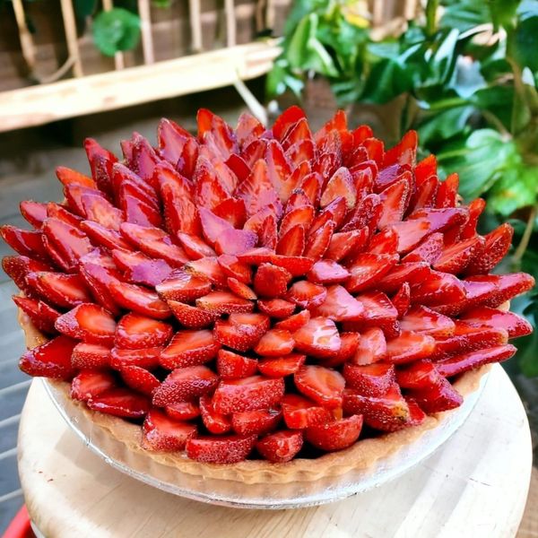 A strawberry tart with beautifully arranged sliced strawberries.
