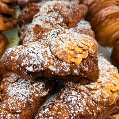 Close-up of almond croissants dusted with powdered sugar.