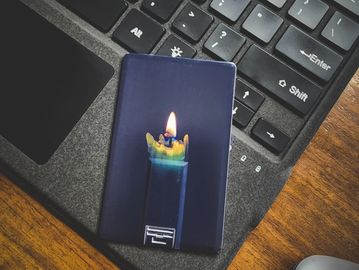 A lighter with a flame design rests on a laptop keyboard.