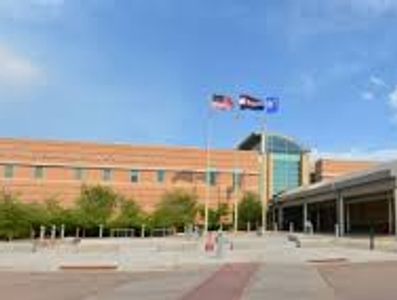 Exterior view of a modern municipal building with three flags flying.
