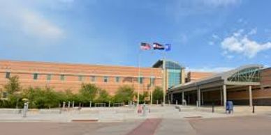 Exterior view of a large modern building with flags and clear sky.