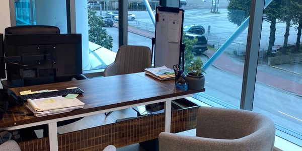 Modern office space with large windows and cozy seating.
