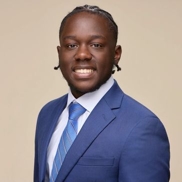 Young man in a blue suit smiling.