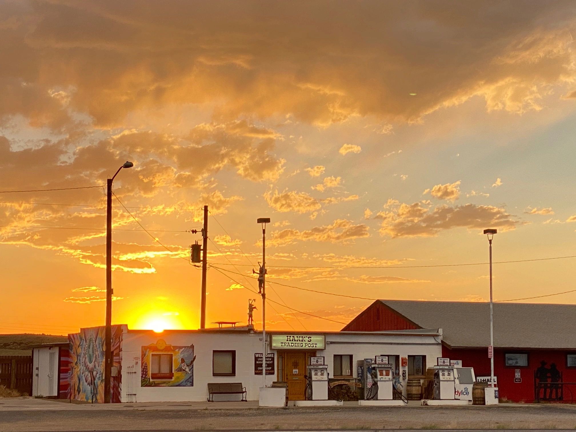 Sunset behind Hank's Trading Post with colorful sky.