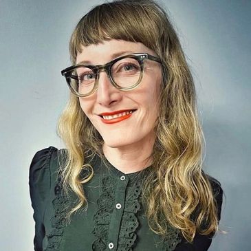 Smiling woman in her thirties wearing luxury eyewear designed by Blake Kuwahara.