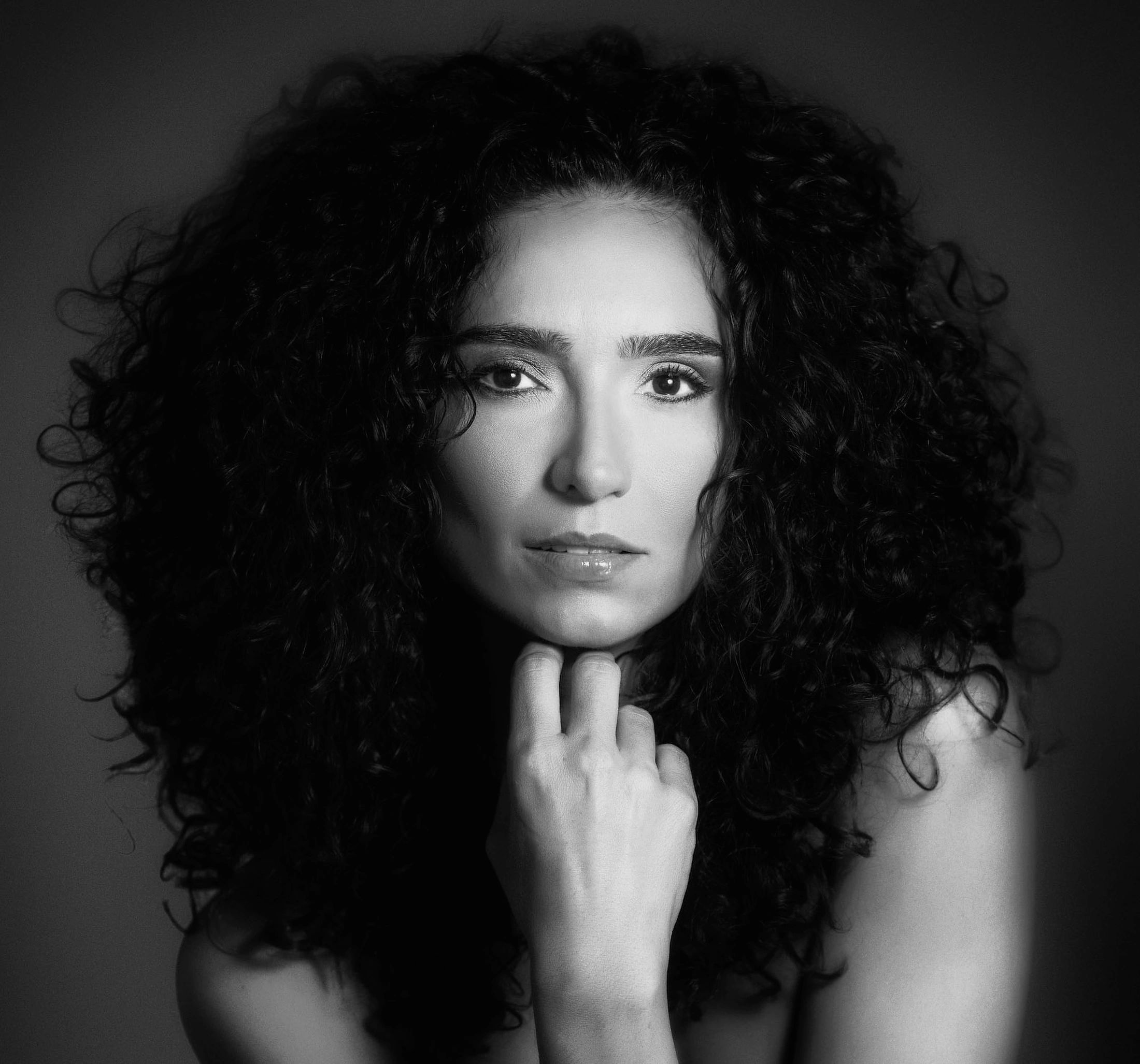 Black and white portrait of a woman with curly hair.