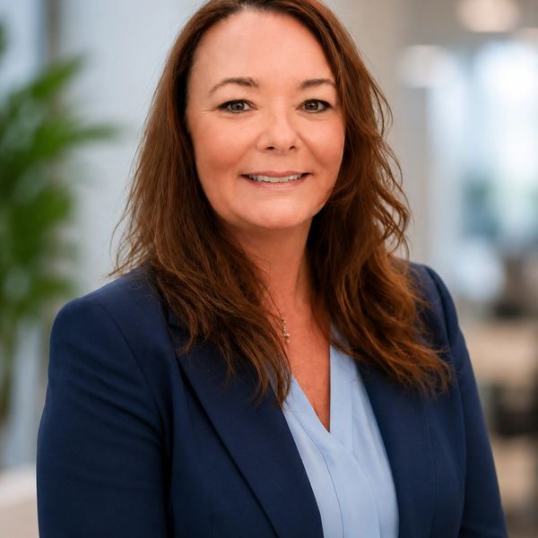 Professional woman in business attire smiling indoors.