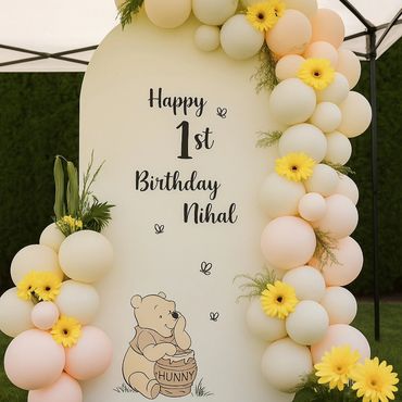 First birthday decoration with Winnie the Pooh and yellow flowers.