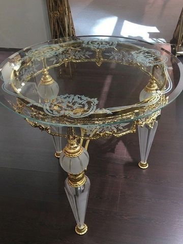 Elegant glass table with gold and crystal detailing on ornate legs.