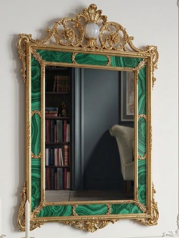 Ornate gold and green framed mirror with baroque detailing.