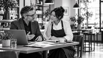 Business discussion in a cafe between a chef and a man.
