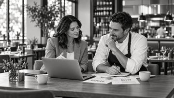 Two colleagues discussing business in a cafe.