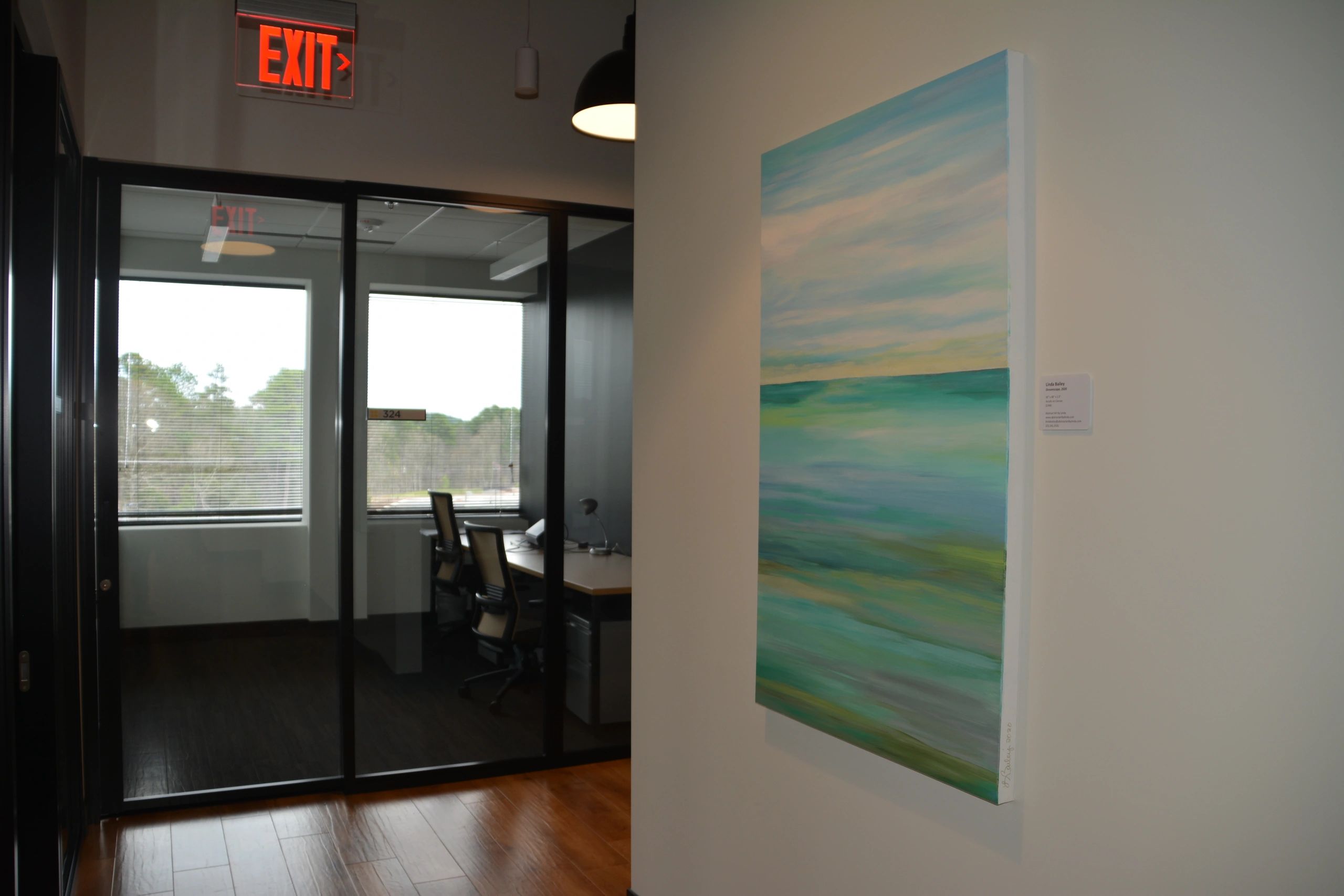 Image of an office wall with a medium size abstract seascape painting. 