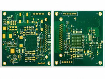 Two green printed circuit boards with gold pads and outlines for components.