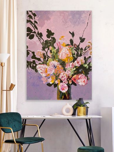 Colorful floral painting with pink and yellow flowers on a purple background above a modern desk.
