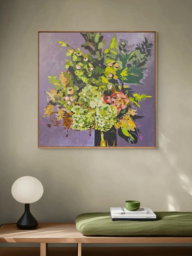 Modern interior with a floral painting, wooden bench, and minimalist lamp.