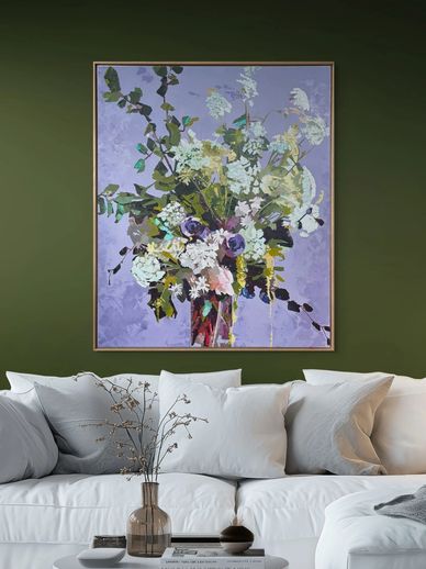 Abstract floral painting above white sofa with green wall.