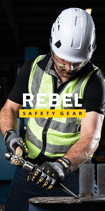 Worker wearing Rebel safety gear using a hammer and chisel.