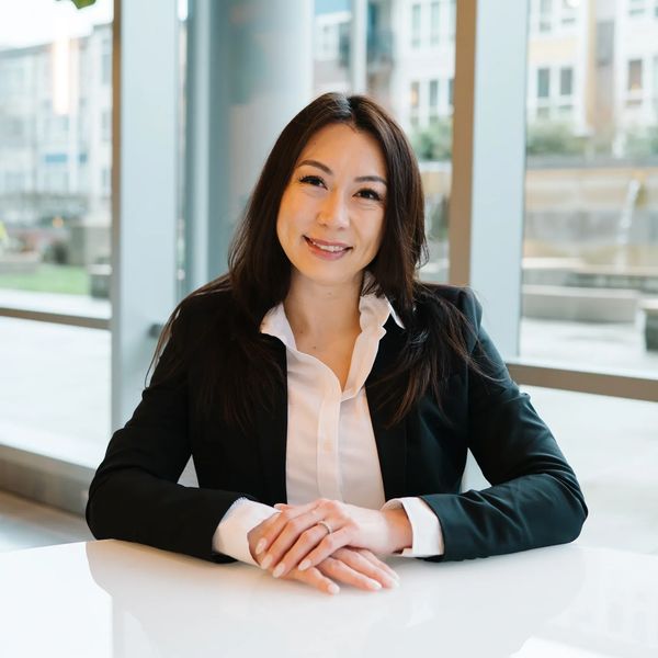 Professional woman smiling confidently at a bright office table.