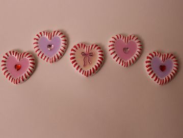 Five heart-shaped decorations with red and white borders.