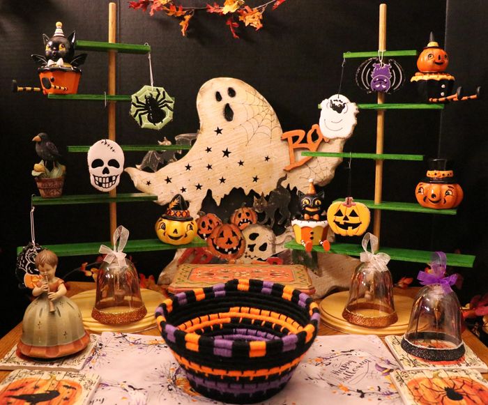 Vintage and handcrafted decorations, along with other items, are arranged in a fun Halloween scene. 