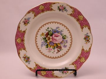 A white ceramic plate with a pink floral border and a gold rim.