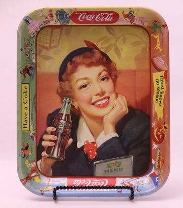 Vintage Coca-Cola tray featuring a smiling woman holding a Coke bottle.