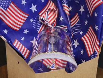 Glass bell with American flag background.