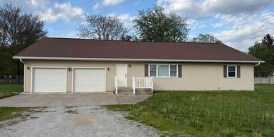 Single-story house with a double garage and a grassy yard.