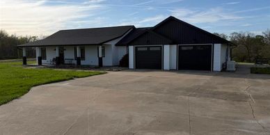 Single-story house with a large driveway and two-car garage.