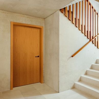 Fire-rated wooden door with modern handle, stairway access, durable design for safety and style.