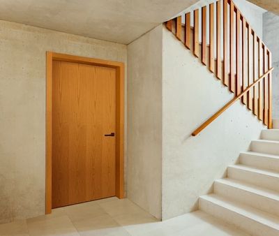 Fire-rated wooden door with modern handle, stairway access, durable design for safety and style.