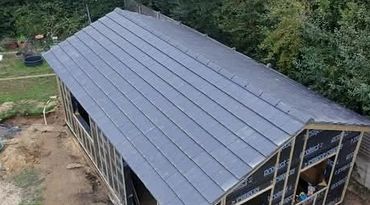 A roof installation on a rectangular building under construction.