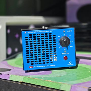 Blue timer device with a knob and warning label on a colorful surface.