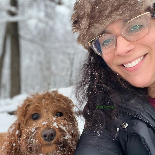 Woman and dog enjoying snowy weather together.