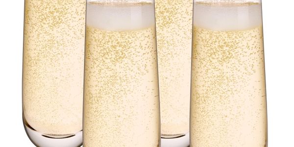 Four glasses filled with sparkling champagne with bubbles rising.