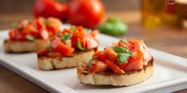 Fresh tomato bruschetta with basil on toasted bread.