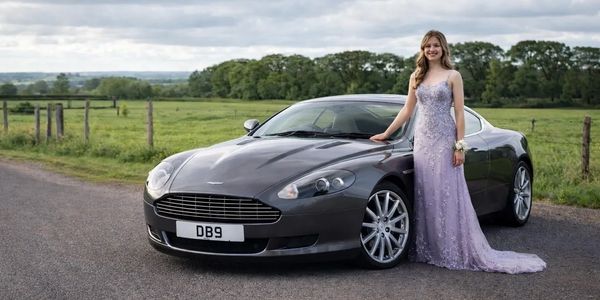 girl in prom dress next to aston martin db9