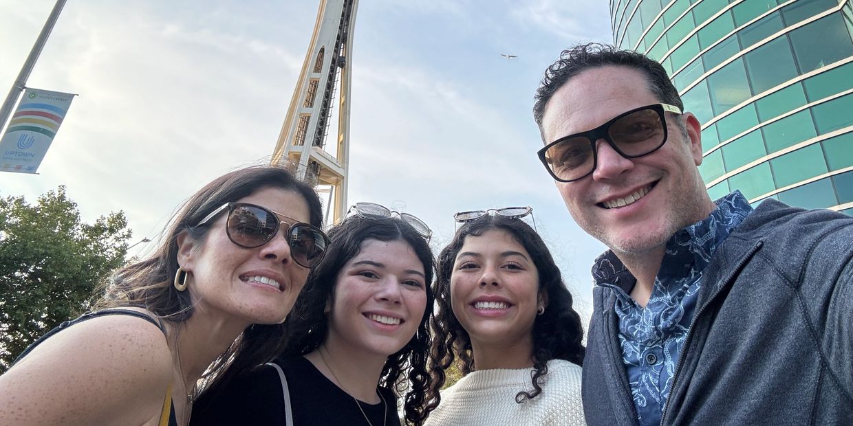 A happy group selfie with the Space Needle in the background in Seattle.