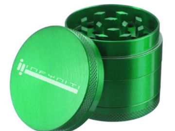 Green metal herb grinder with lid off.