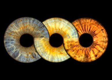 Three colorful human iris close-ups on a black background.