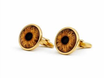 Gold cufflinks designed like human eyes.