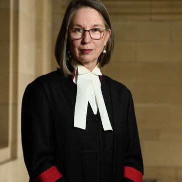Female judge in formal judicial attire.