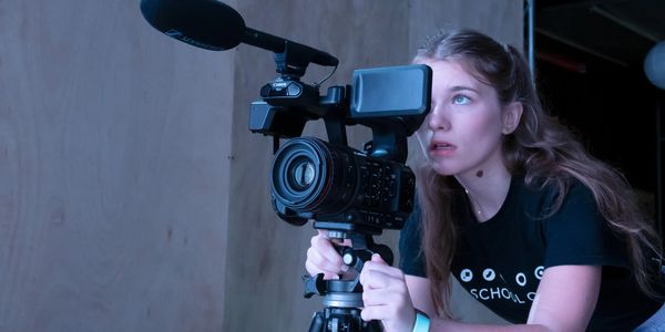 Young woman operating a professional video camera.