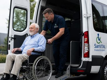 Caregiver assisting an elderly man in a wheelchair by a medical transport van.